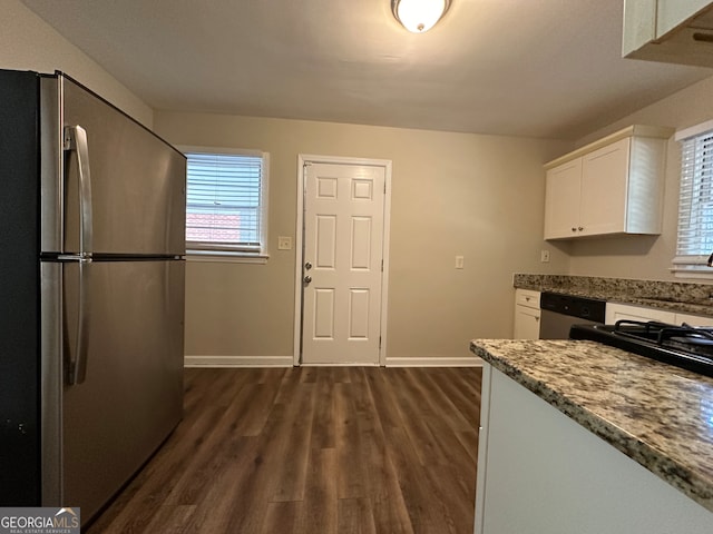 kitchen featuring white cabinets, appliances with stainless steel finishes, stone countertops, dark wood-type flooring, and sink