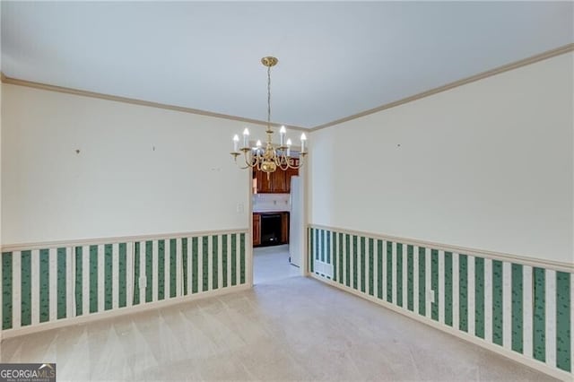 carpeted spare room with a chandelier and ornamental molding