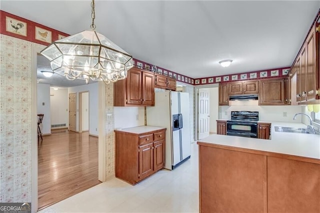 kitchen with black electric range, white fridge with ice dispenser, light wood-type flooring, kitchen peninsula, and decorative light fixtures