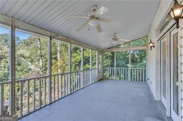 unfurnished sunroom featuring lofted ceiling, a healthy amount of sunlight, and ceiling fan