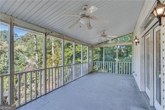 unfurnished sunroom featuring a ceiling fan