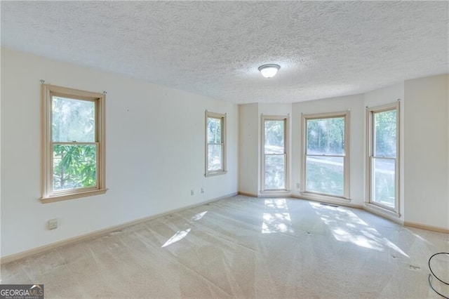 carpeted empty room featuring a textured ceiling