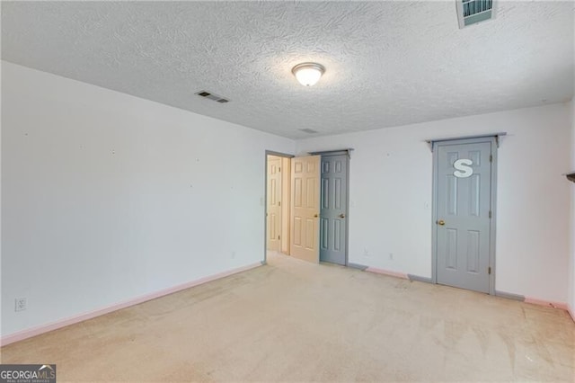 unfurnished room featuring carpet and a textured ceiling