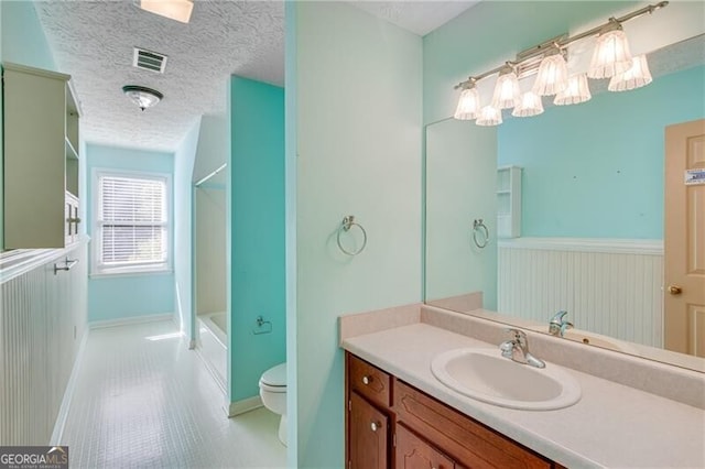 full bathroom with toilet, vanity, tile patterned flooring, shower / bath combination, and a textured ceiling