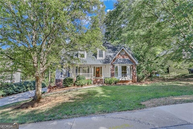 view of front of home featuring covered porch and a front lawn