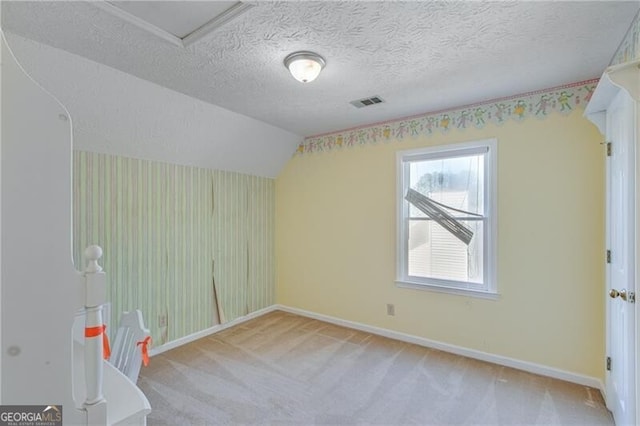 bonus room featuring a textured ceiling, light colored carpet, and vaulted ceiling