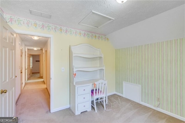 carpeted bedroom featuring a textured ceiling, attic access, baseboards, and lofted ceiling