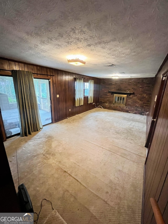 726 Victoria Cir, Dublin, GA 31021 - unfurnished living room featuring a textured ceiling, wood walls, and light colored carpet