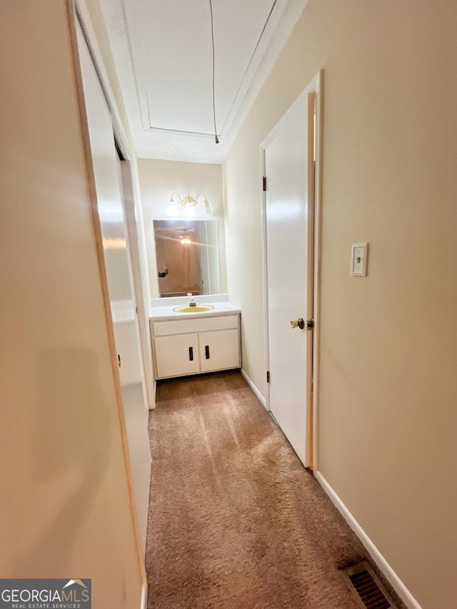 726 Victoria Cir, Dublin, GA 31021 - hall featuring light carpet, attic access, a sink, and baseboards