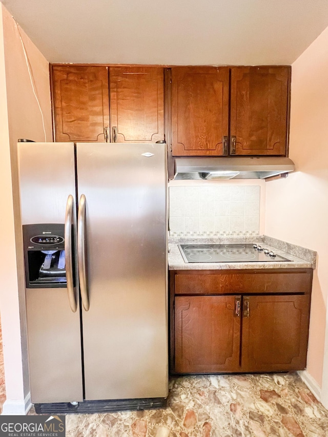 726 Victoria Cir, Dublin, GA 31021 - kitchen featuring stainless steel refrigerator with ice dispenser, under cabinet range hood, brown cabinetry, black electric cooktop, and light countertops