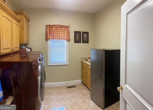 washroom with light tile patterned flooring, separate washer and dryer, and cabinets