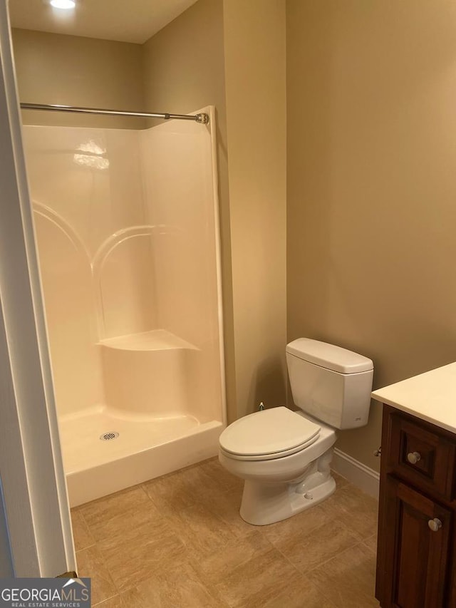 bathroom with toilet, vanity, and a shower