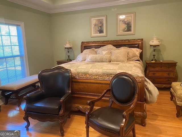 bedroom with ornamental molding and light hardwood / wood-style floors