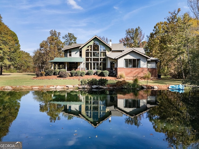 back of house featuring a yard and a water view