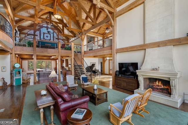 living room with dark wood-type flooring, beam ceiling, high vaulted ceiling, and a fireplace