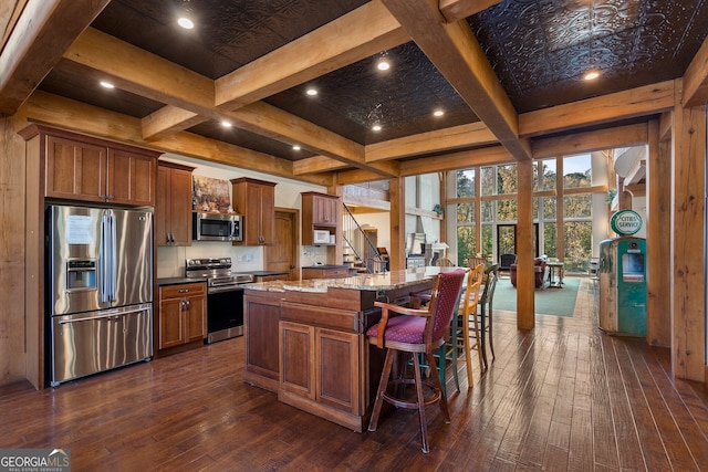 kitchen featuring a center island, stainless steel appliances, a kitchen bar, and dark hardwood / wood-style flooring