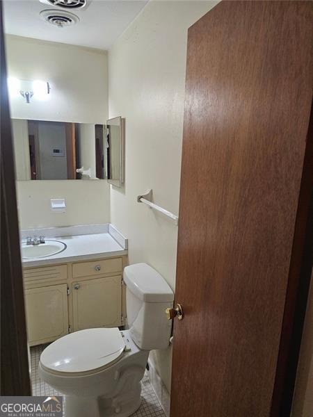 bathroom with vanity, toilet, and tile patterned flooring