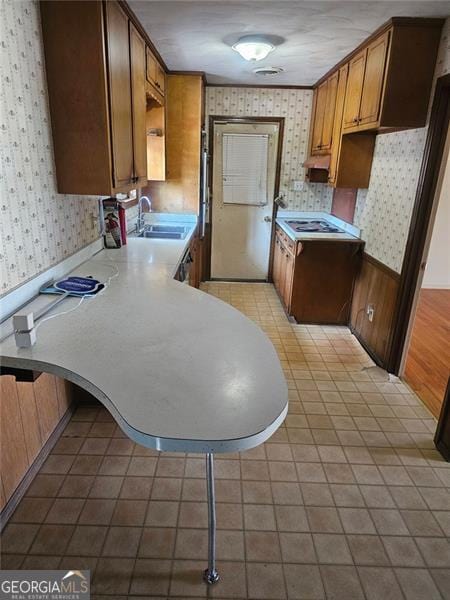 kitchen featuring sink, white electric stovetop, kitchen peninsula, and light hardwood / wood-style floors