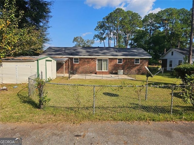 rear view of house featuring a storage shed and a lawn