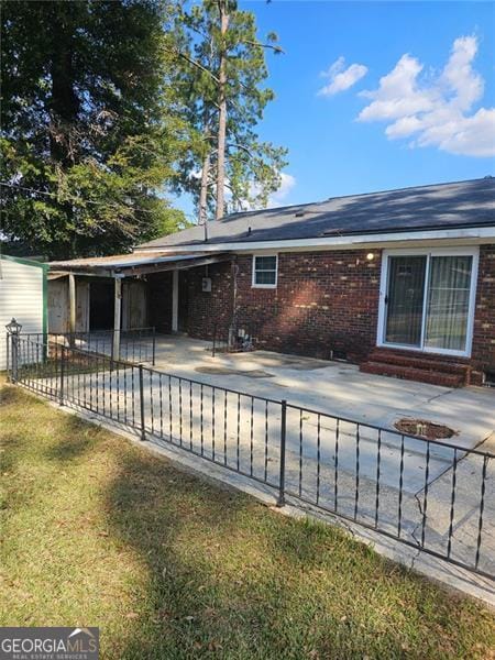 rear view of property with a yard and a patio area