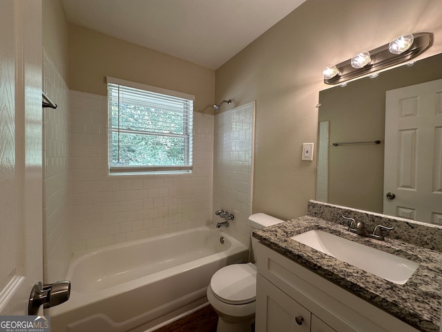 full bathroom featuring vanity, tiled shower / bath combo, and toilet