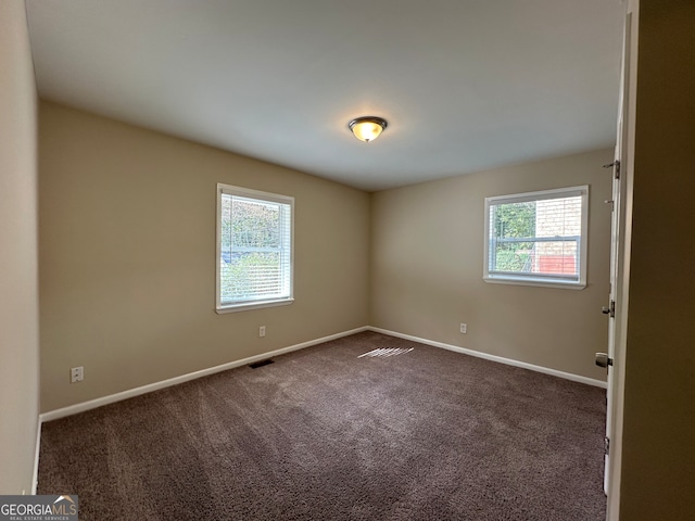 carpeted spare room featuring plenty of natural light