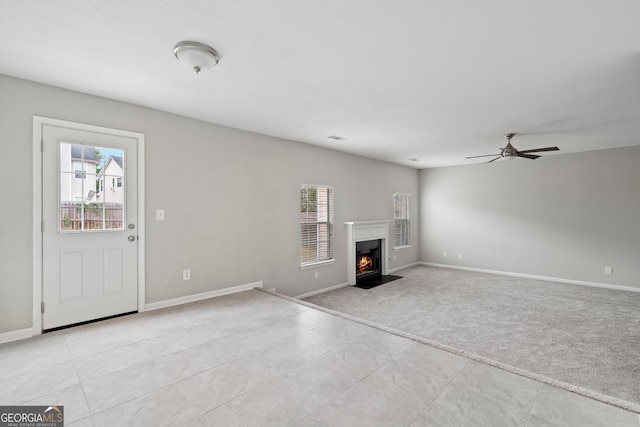 unfurnished living room featuring ceiling fan and light carpet