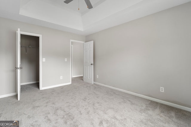 unfurnished bedroom featuring light carpet, a closet, and ceiling fan