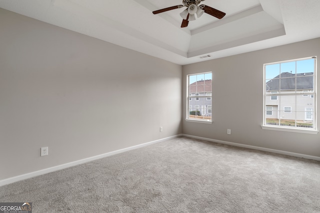 unfurnished room with ceiling fan, carpet, and a raised ceiling