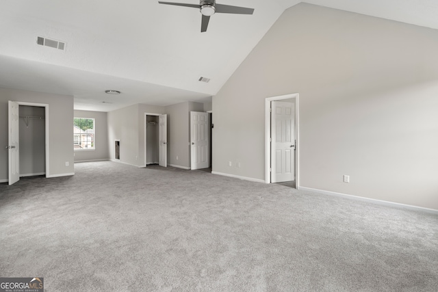 spare room with ceiling fan, high vaulted ceiling, and carpet