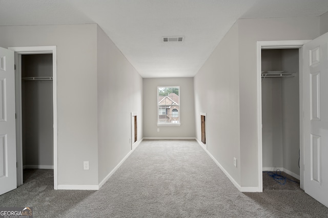 unfurnished bedroom with two closets and carpet flooring