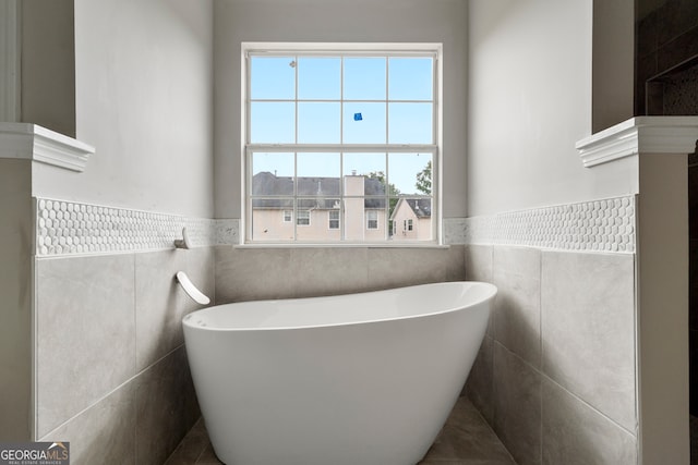 bathroom featuring a tub to relax in and tile walls