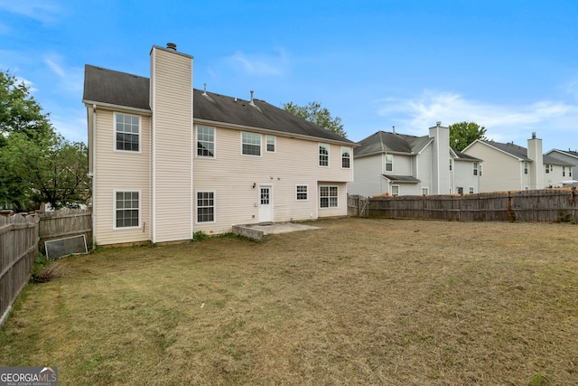 back of house featuring a patio and a yard