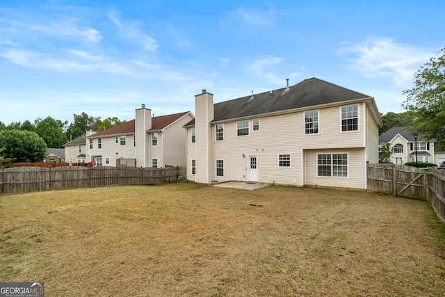 rear view of house featuring a yard and a patio area