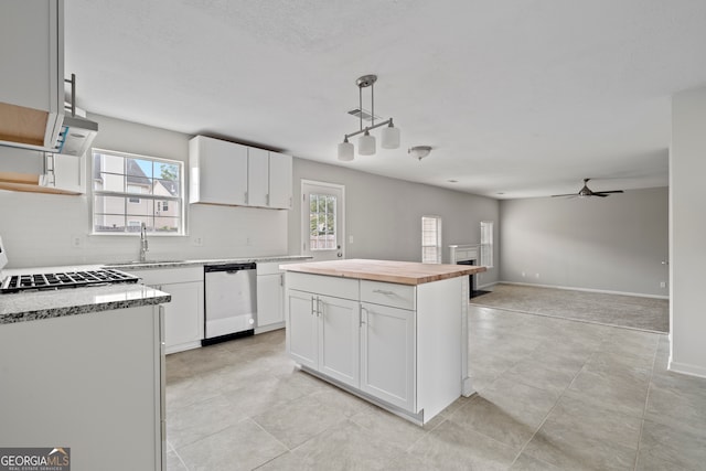 kitchen with white cabinetry, pendant lighting, a wealth of natural light, and stainless steel dishwasher