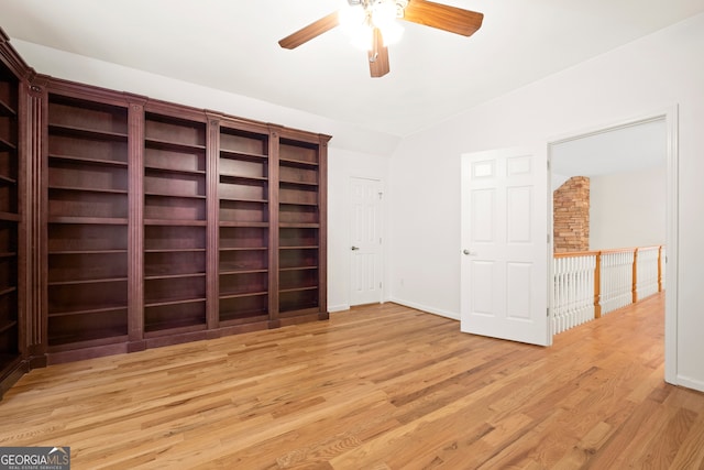 empty room featuring light hardwood / wood-style flooring, vaulted ceiling, and ceiling fan