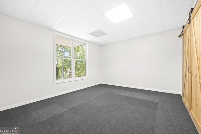 124 S Shore Dr, Fair Play, SC 29643 - spare room with a barn door, a drop ceiling, baseboards, and dark carpet