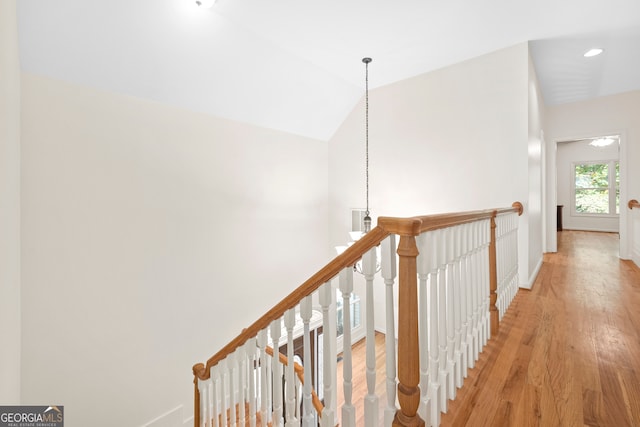 hall featuring light hardwood / wood-style flooring and lofted ceiling