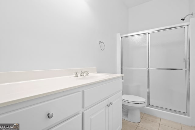 bathroom featuring vanity, toilet, walk in shower, and tile patterned flooring