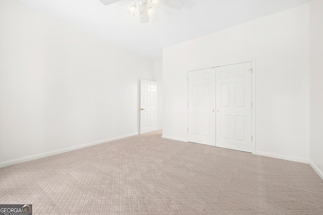 unfurnished bedroom with a closet, ceiling fan, and light carpet