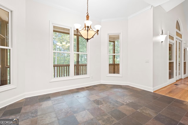 unfurnished dining area featuring crown molding, a notable chandelier, and a wealth of natural light