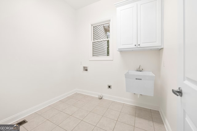 laundry room with sink, light tile patterned floors, cabinets, and hookup for a washing machine