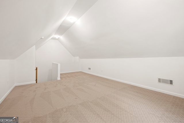 bonus room featuring light carpet and vaulted ceiling