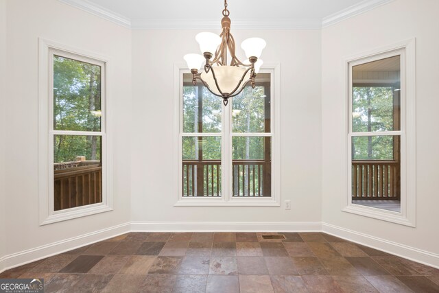 unfurnished dining area with crown molding, a healthy amount of sunlight, and a chandelier