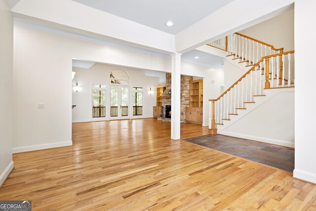 124 S Shore Dr, Fair Play, SC 29643 - unfurnished living room with wood finished floors, a stone fireplace, stairs, baseboards, and recessed lighting