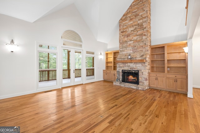 unfurnished living room featuring high vaulted ceiling, light hardwood / wood-style flooring, and a fireplace