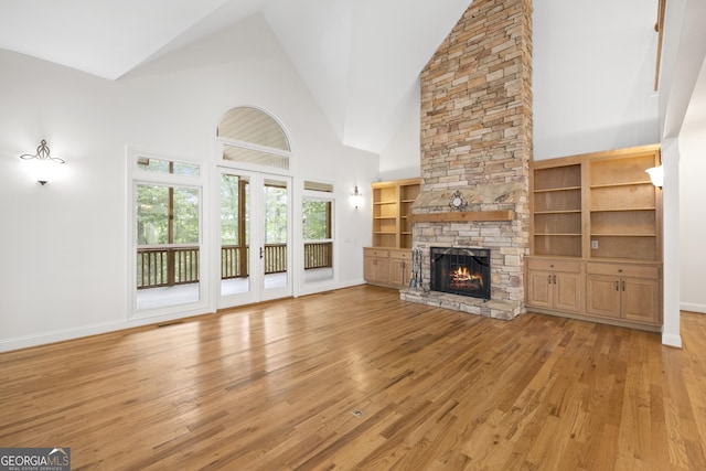 124 S Shore Dr, Fair Play, SC 29643 - unfurnished living room with high vaulted ceiling, light wood-style floors, a stone fireplace, and baseboards