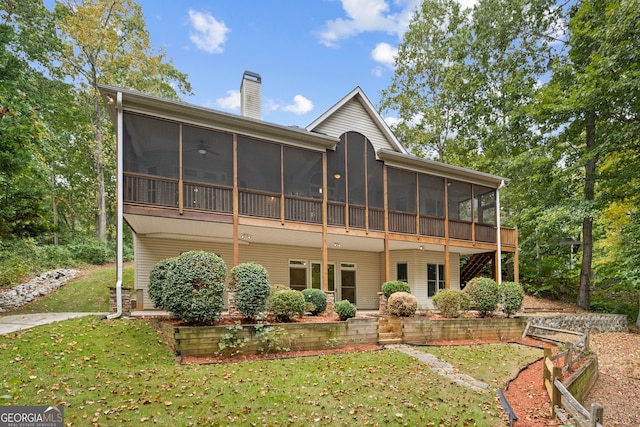 back of property featuring a lawn and a sunroom