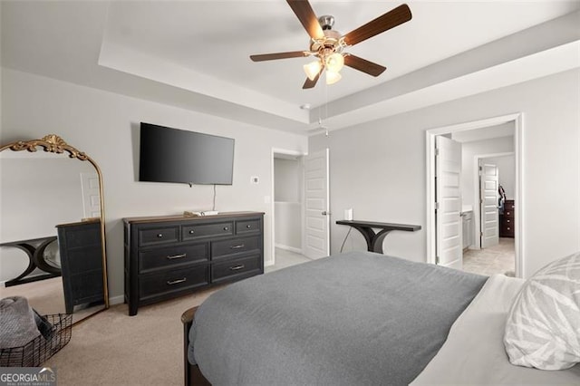 carpeted bedroom with ensuite bath and ceiling fan