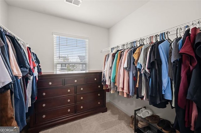 walk in closet featuring light carpet